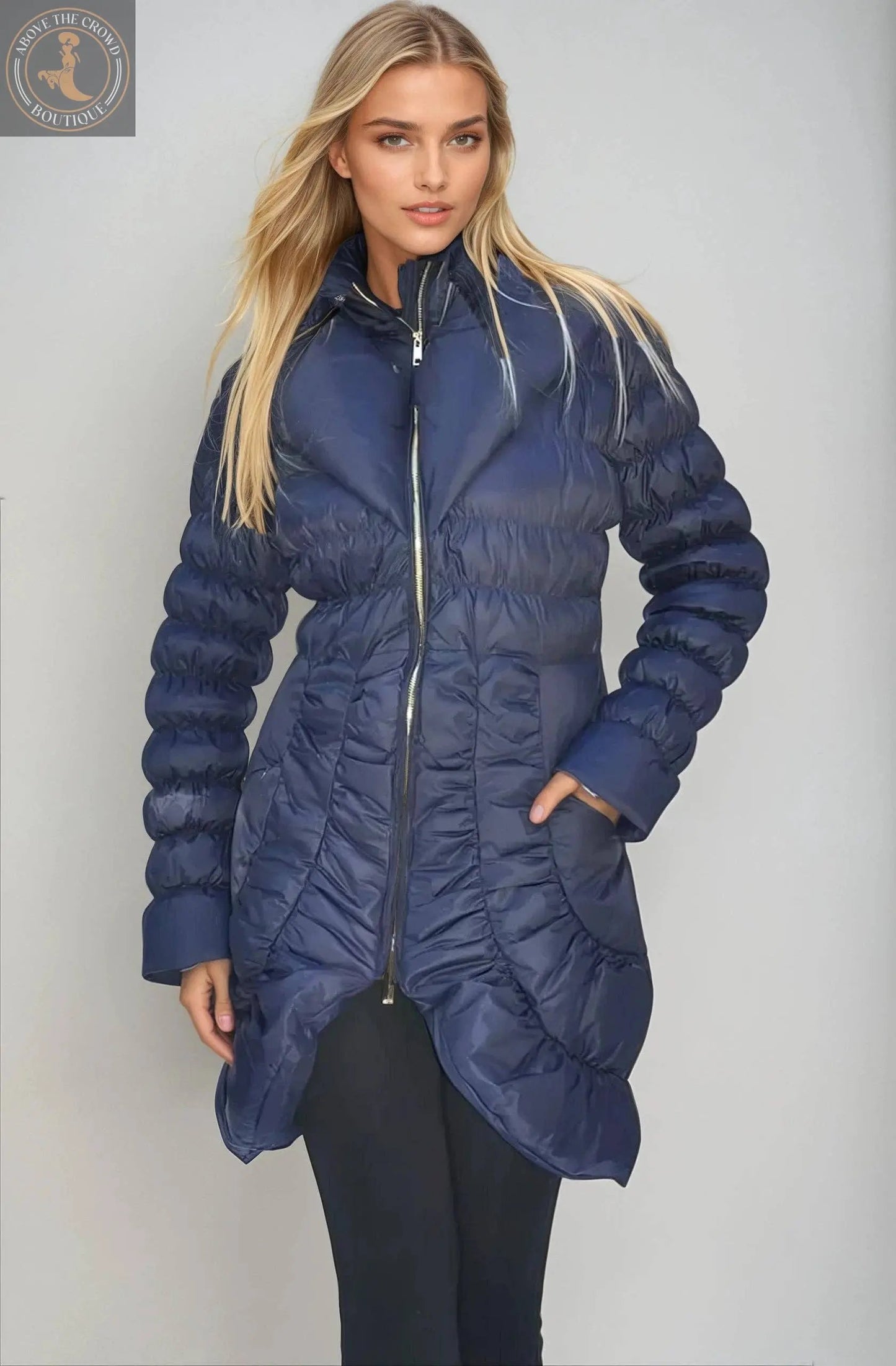 Woman wearing a blue puffer jacket on a gray background
