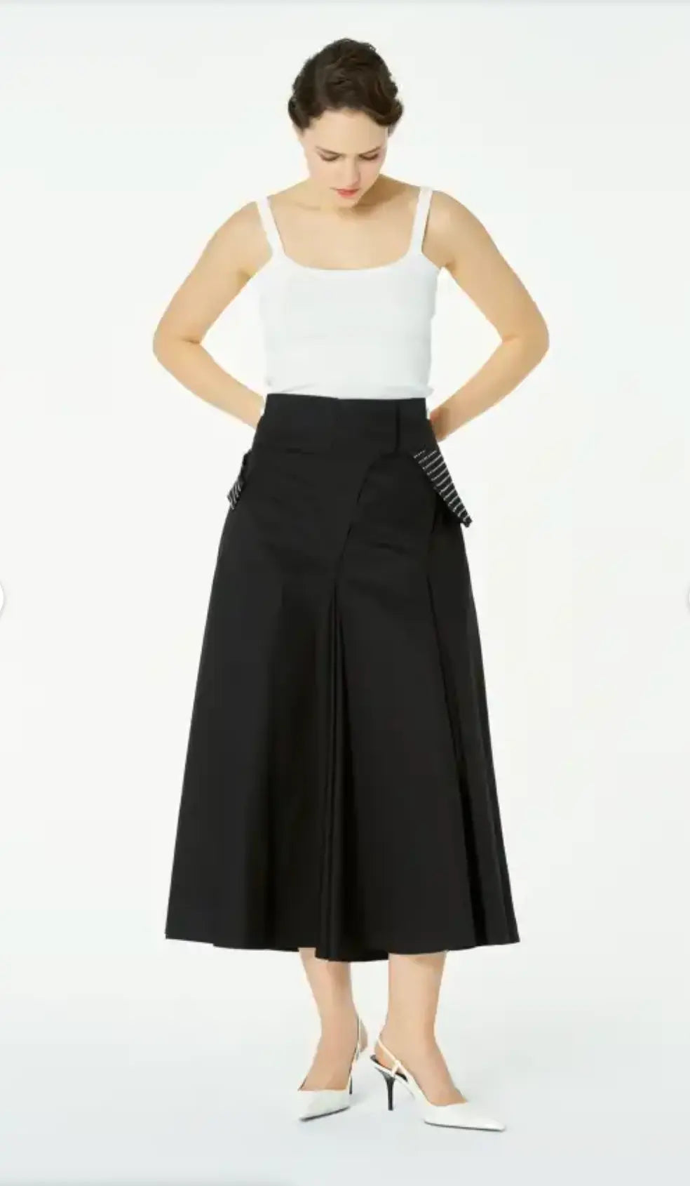 Woman wearing a white top and black skirt on a white background