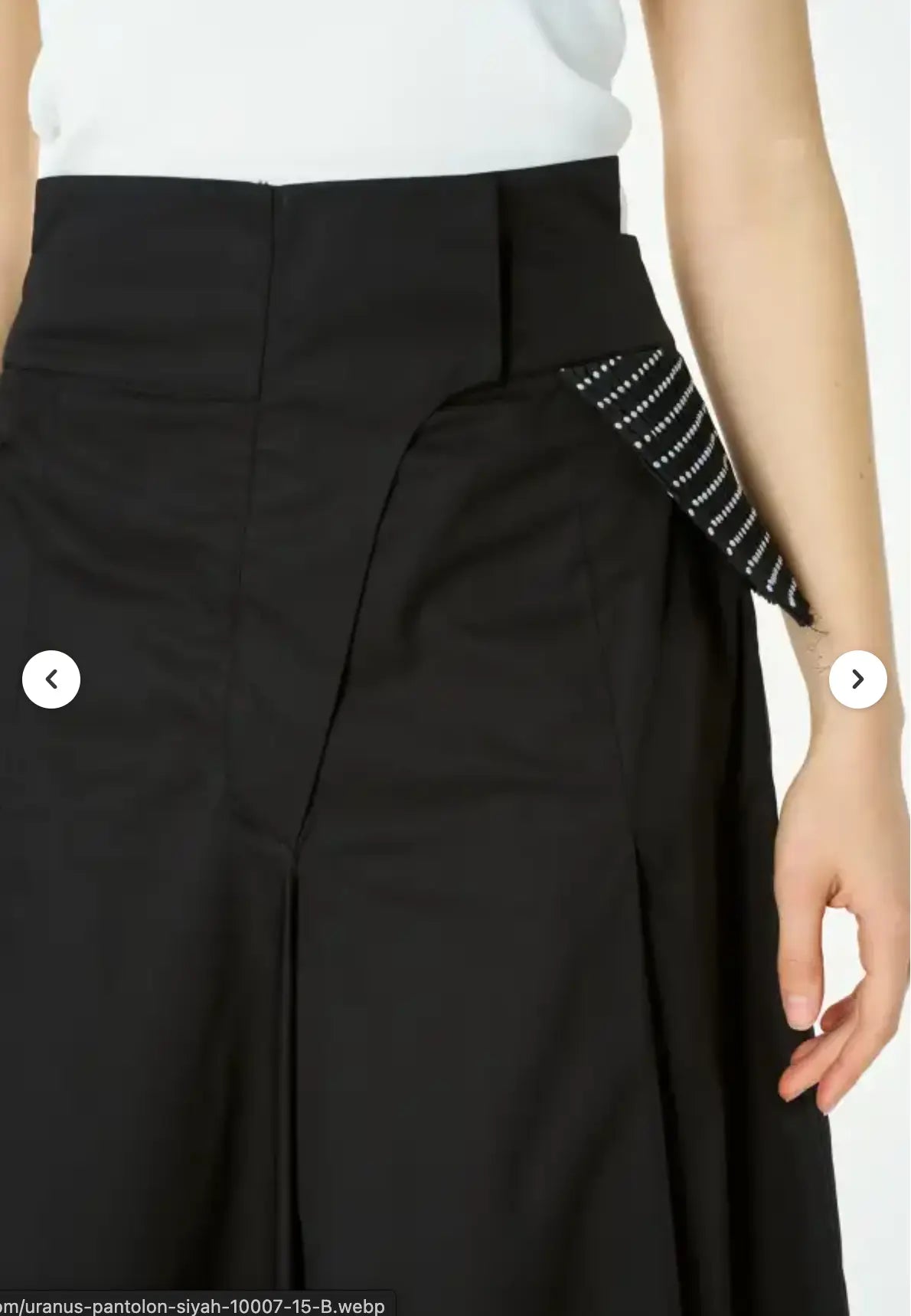 Black pants with a white top and black and white patterned sleeve on a white background