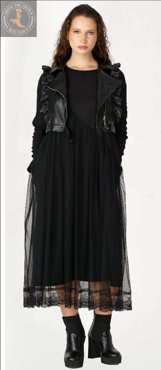 Woman wearing a black dress with sheer overlay and leather accents on a white background